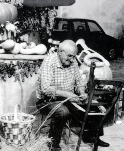 Primo Cumani fotografato nel 2000 mentre esegue l'attività di impagliatore durante la "Fira di Sdàz" (foto Luigi Ropa Esposti